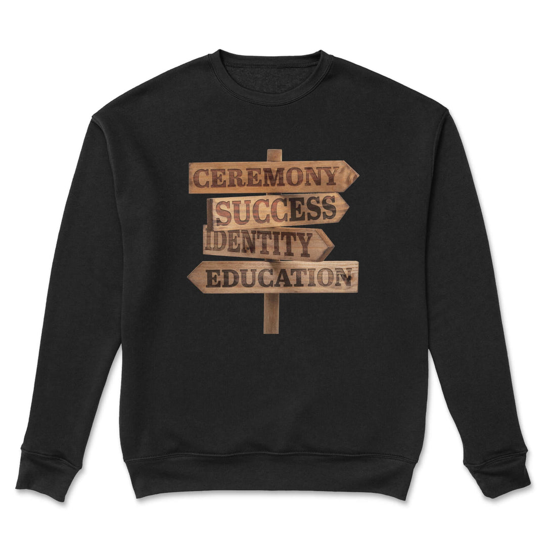 Red Road Crewneck – Indigenous streetwear shirt featuring a wooden signpost with the words Ceremony, Success, Identity, and Education.