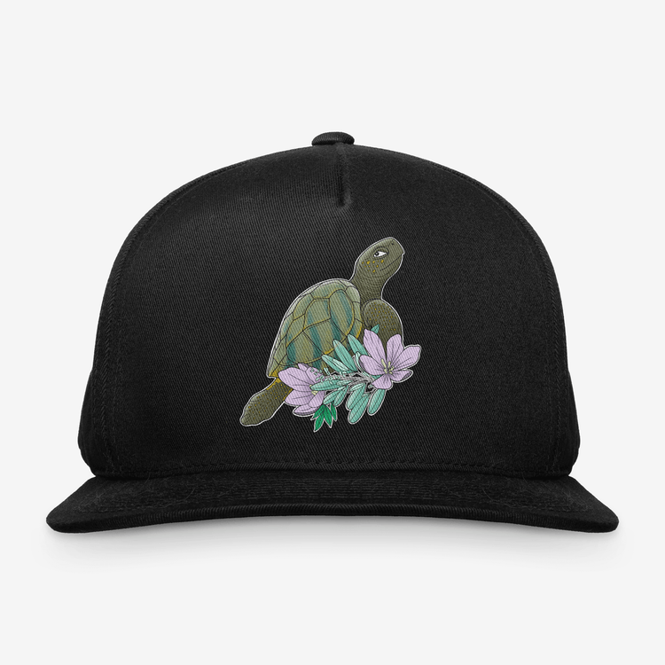 Black snapback hat with printed turtle and pastel flowers representing truth in Anishinaabe teachings, designed by Red Rebel Armour.